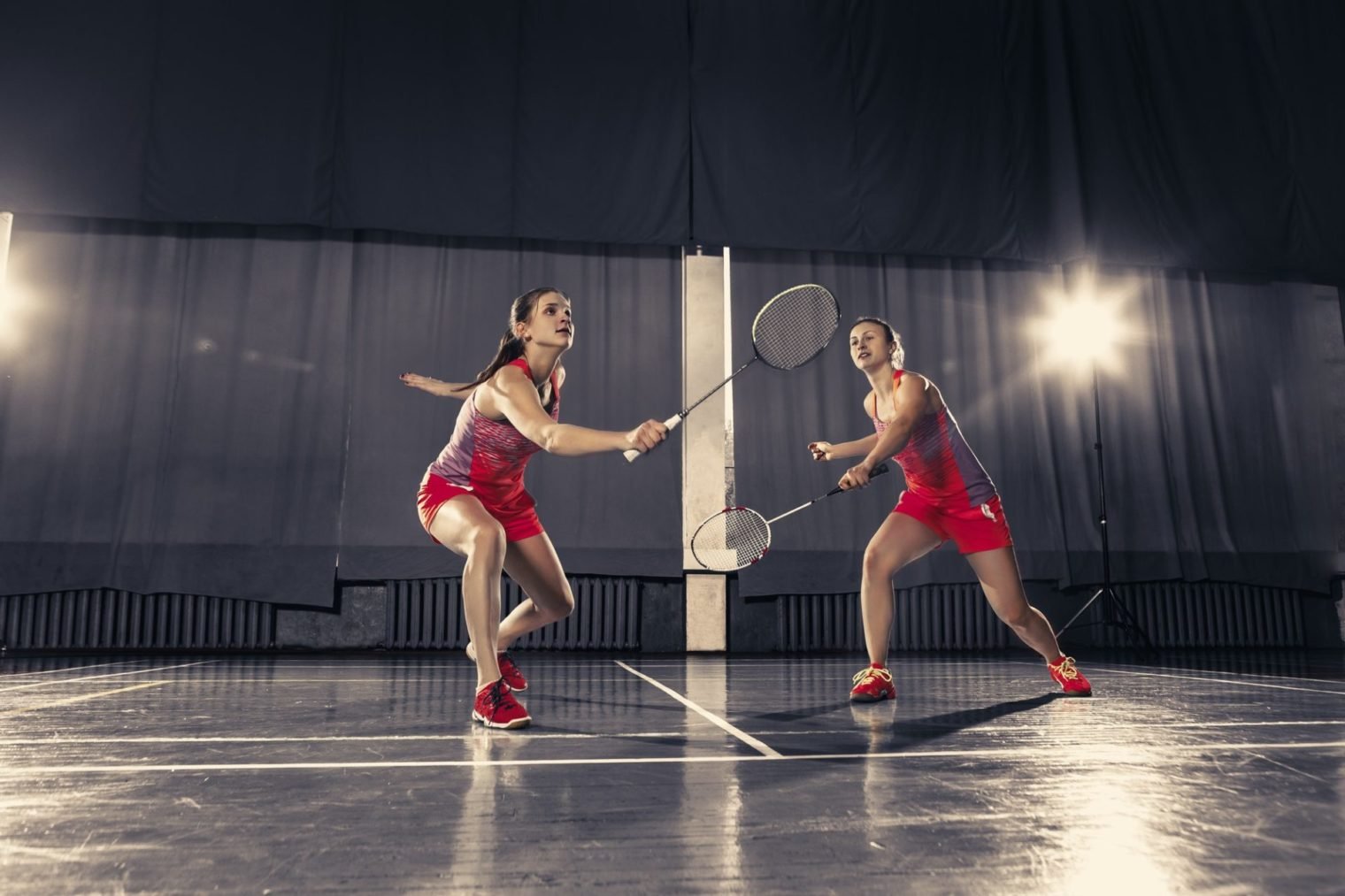 young-women-playing-badminton-at-gym-e1657184708714